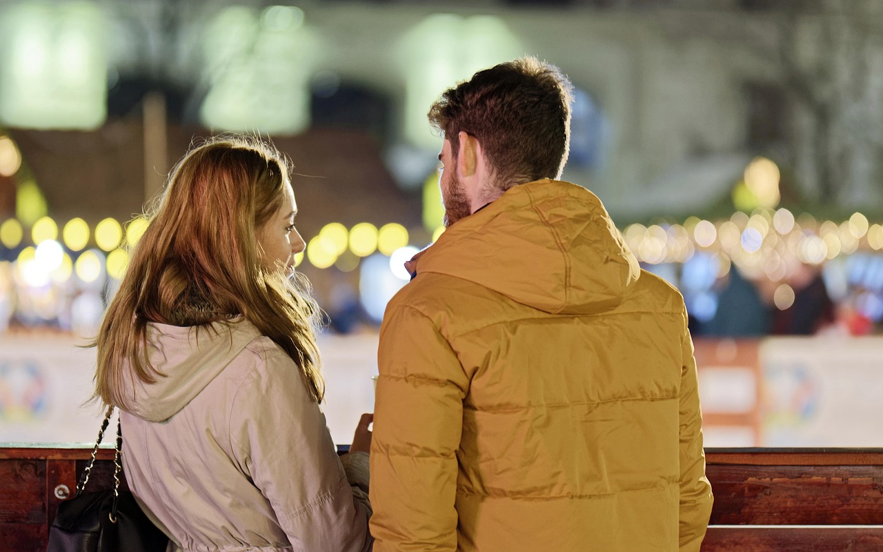 Merry Christmas  Couple  Young People  People  Blonde  Friendship  Together  Talking  Fence  Winter  Holiday  Lights  Ornaments  Decoration  Back View  Snapshot