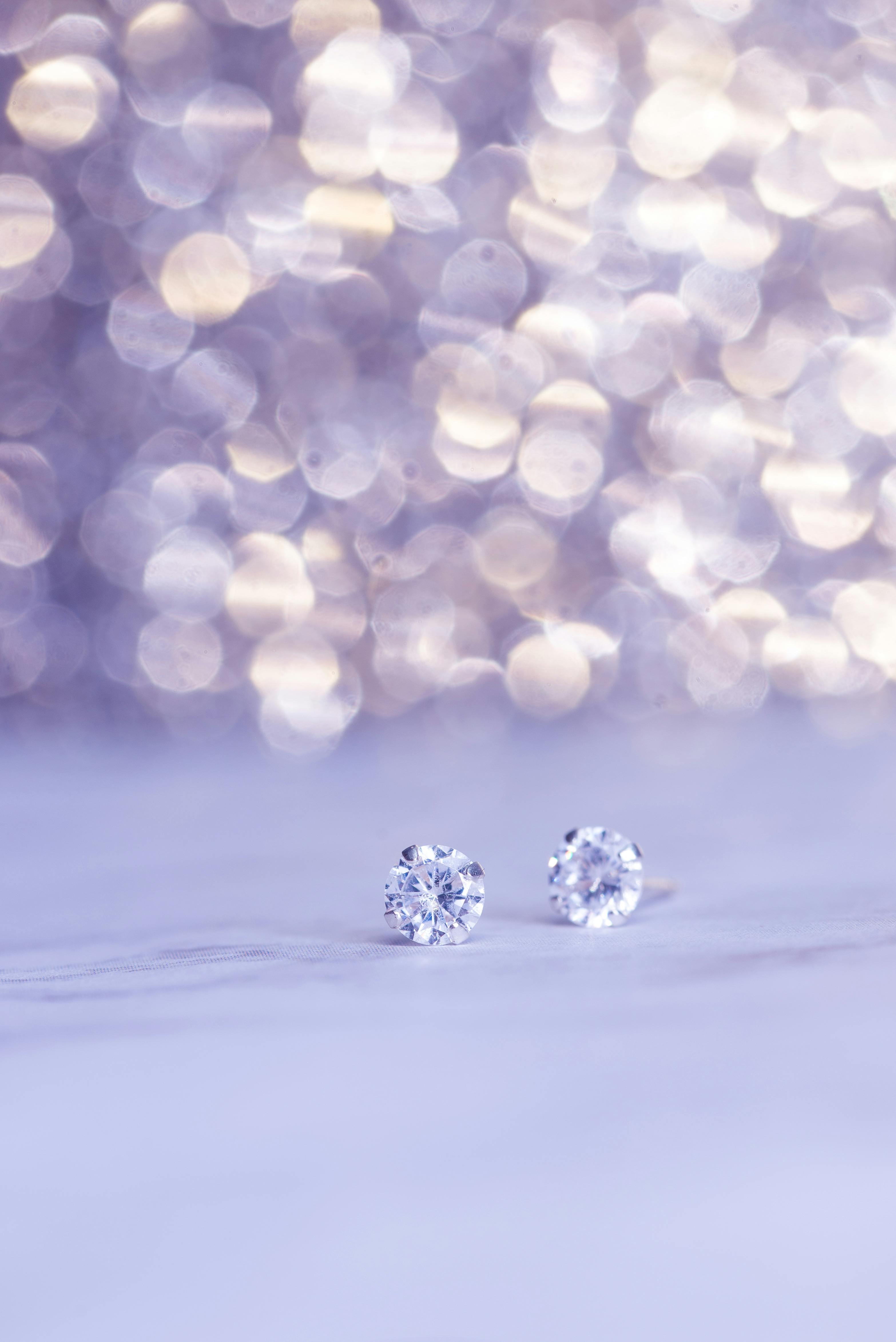 Close Up Shot Of Sparkling Diamond Earrings Against A Beautiful Bokeh Background, Showcasing Luxury.